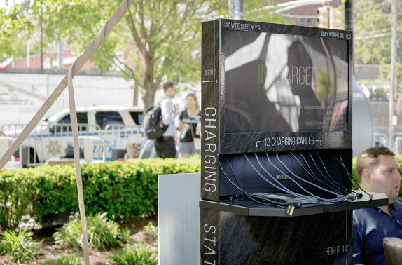 Flex cell phone charging station at outdoor event with greenery