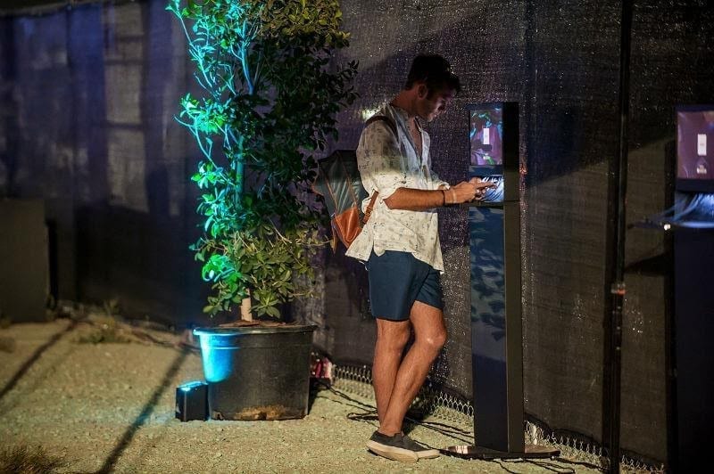 Safe charging cell phone kiosk at music festival