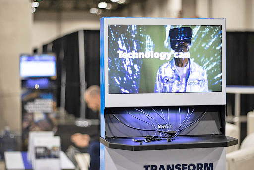 Branded cell phone charging station at trade show event with digital screen