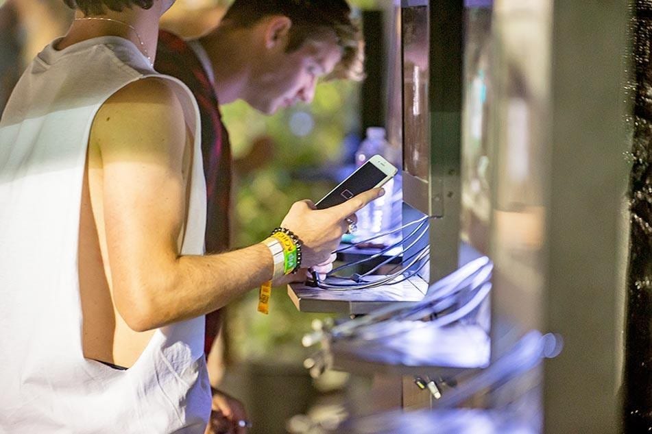 Man using cell phone charging station with dead phone no battery
