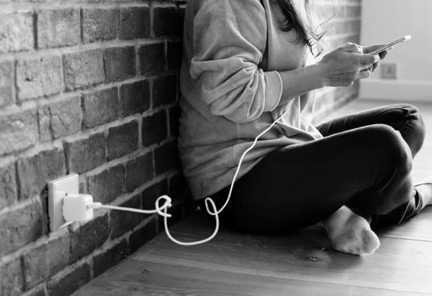 young woman using smartphone as it is being charged